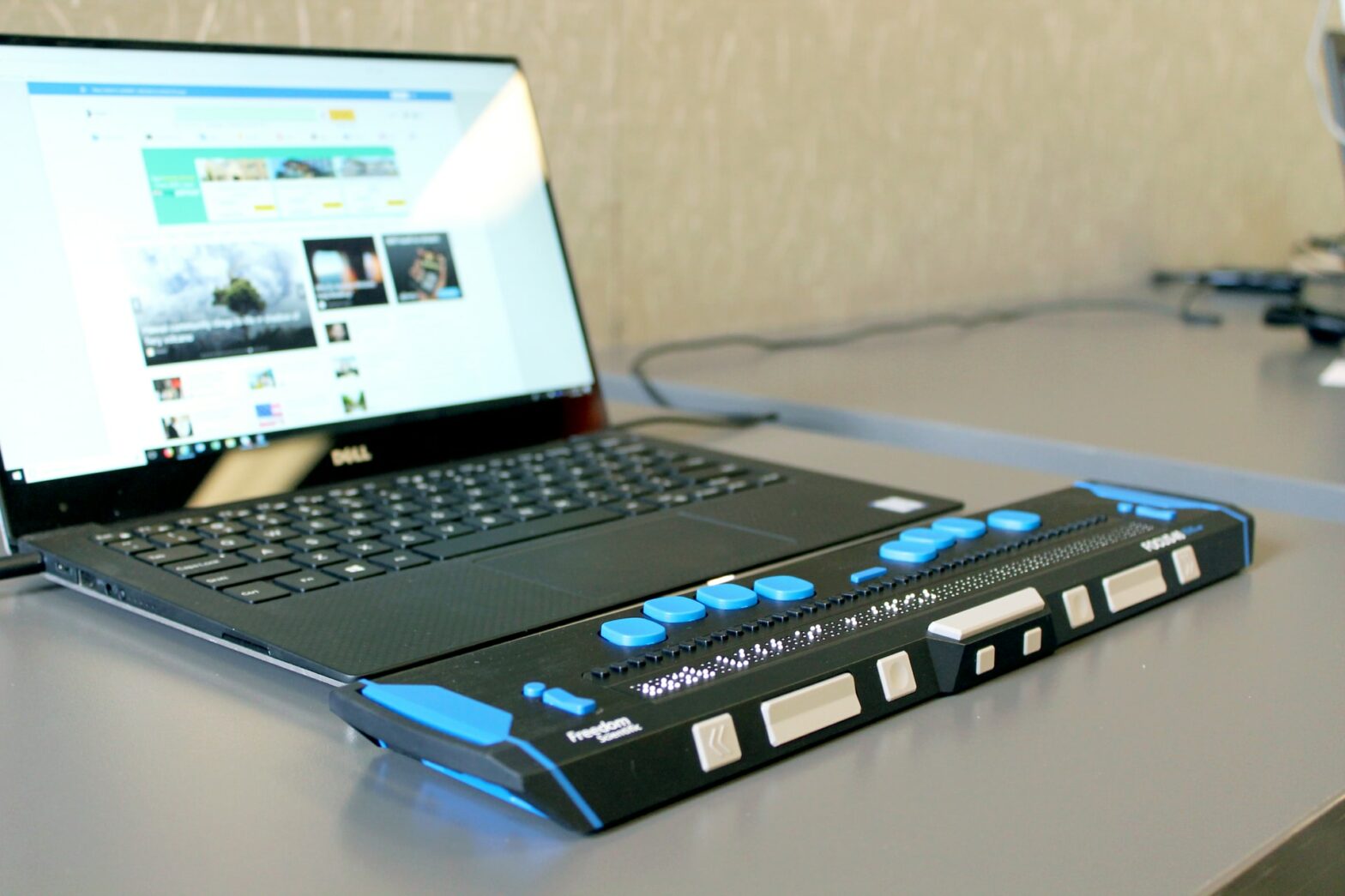 Braille display connected to a laptop that is ajar