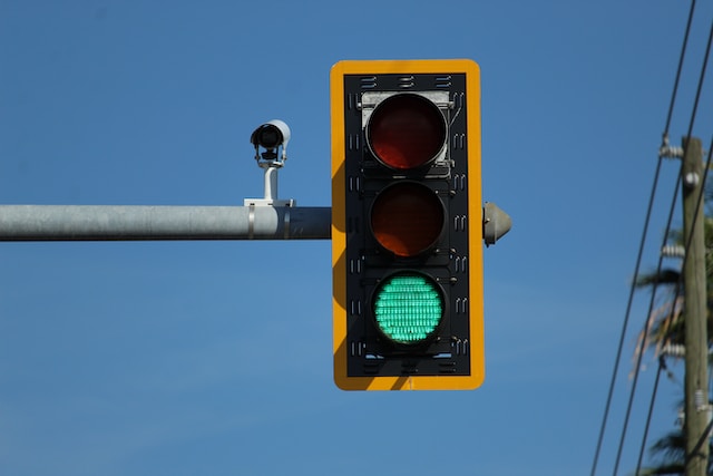 A traffic light displaying a green light in the bottom position, indicating that it is safe to proceed.